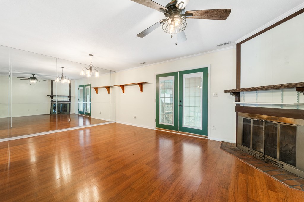 an empty living room with wood floors and a fireplace