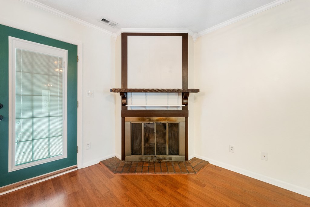 a living room with a fireplace and a window and a door