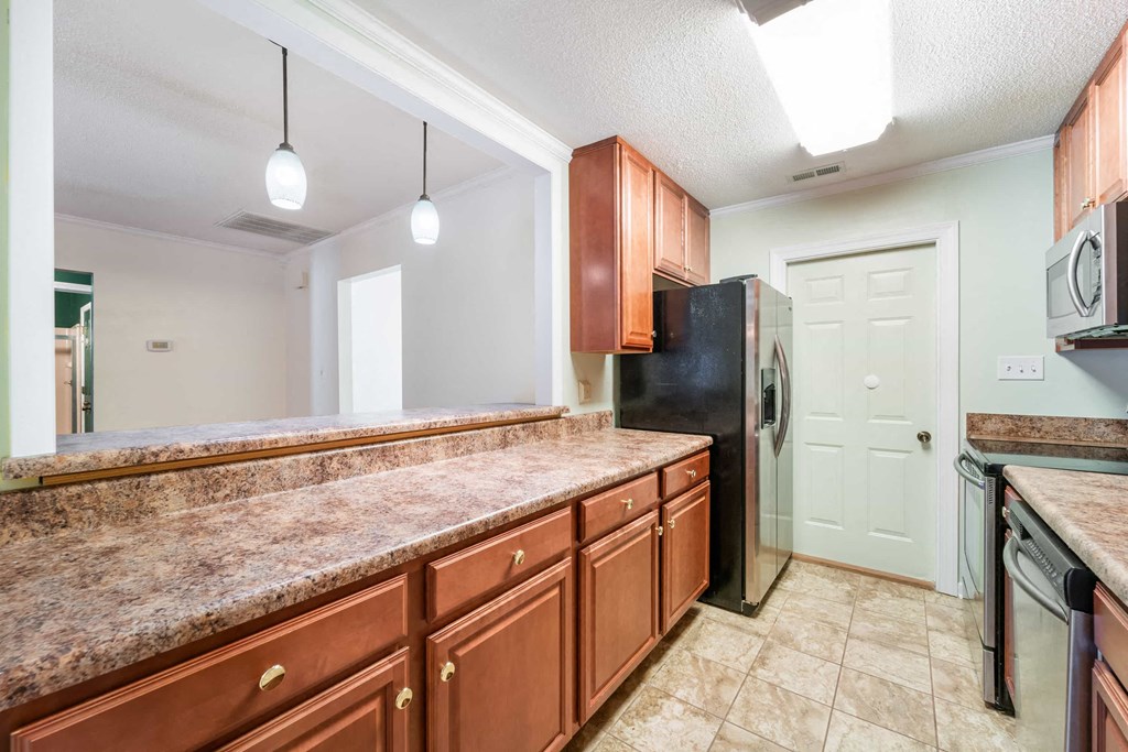 a kitchen with wooden cabinets and a stainless steel refrigerator