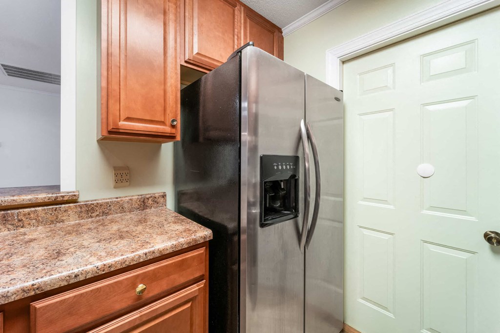 a kitchen with a stainless steel refrigerator and wooden cabinets