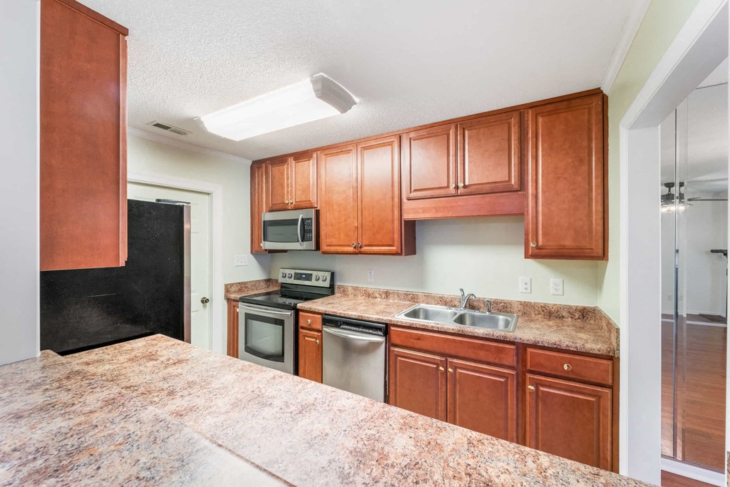 a kitchen with wooden cabinets and stainless steel appliances