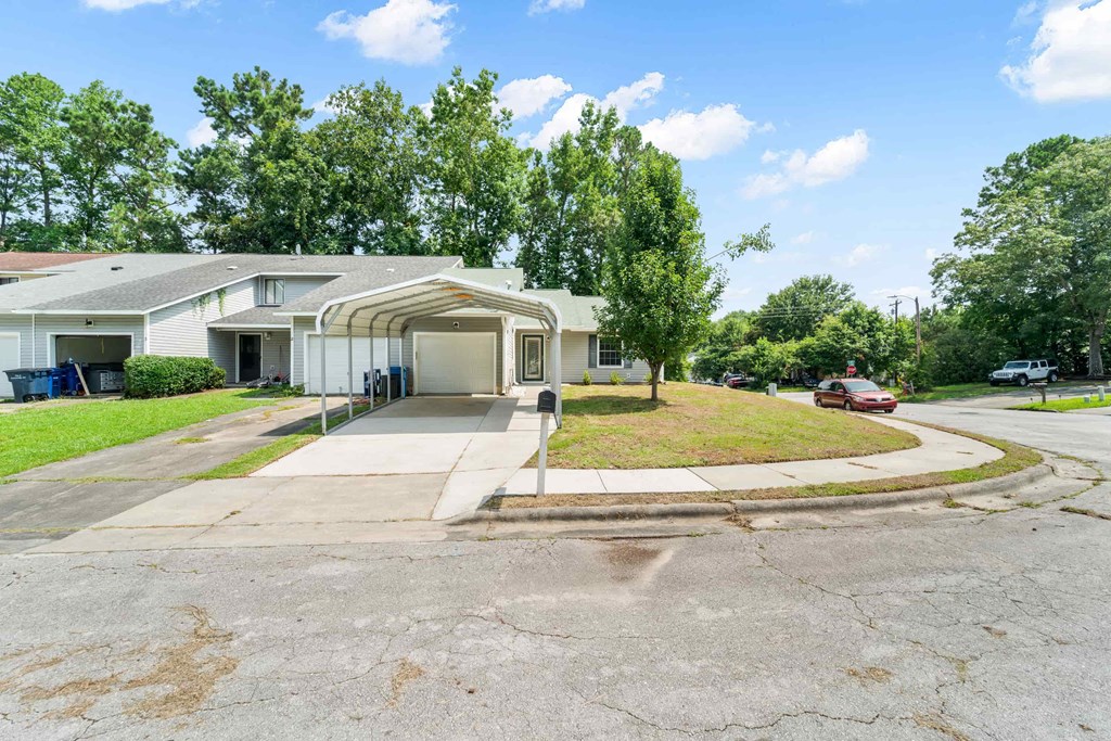 a white house with a driveway and a parking lot