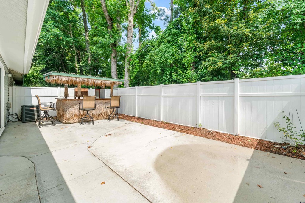 a patio with a gazebo and a white fence