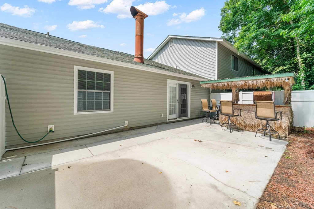 the backyard has a patio with chairs and a gazebo