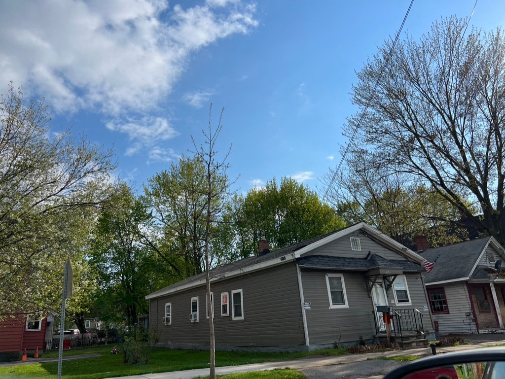 a gray house on the corner of a street