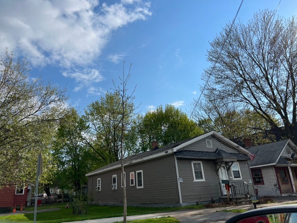 a gray house on the corner of a street