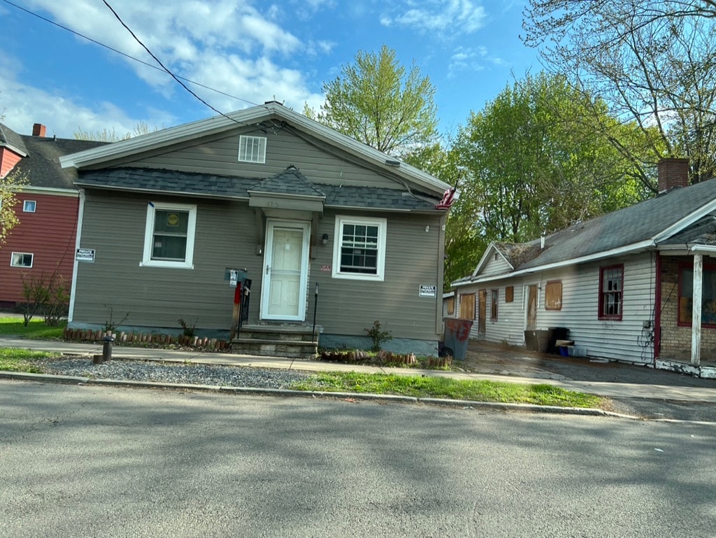 a gray house with a street in front of it