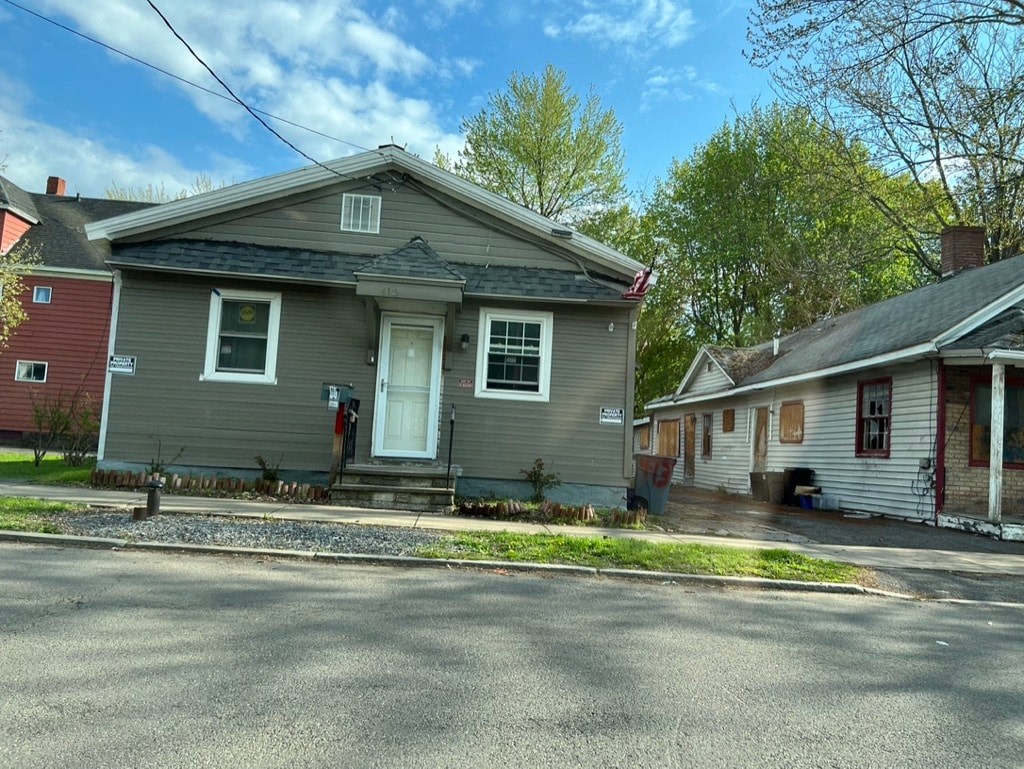 a gray house with a street in front of it