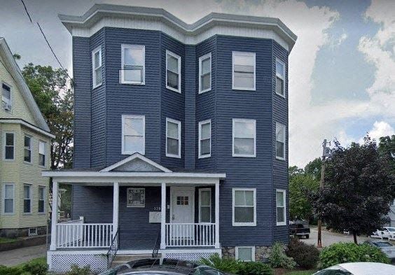 a blue house with a white roof and a car in front of it