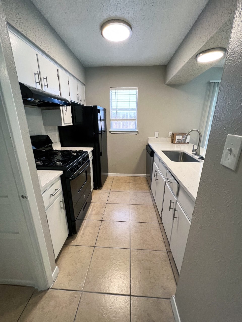 a kitchen with white cabinets and black and white appliances