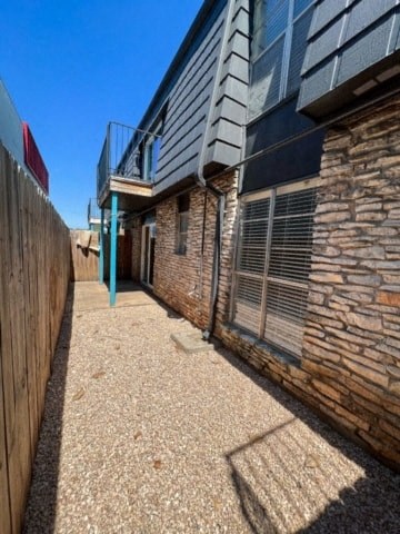 a brick building with a balcony and a wooden fence