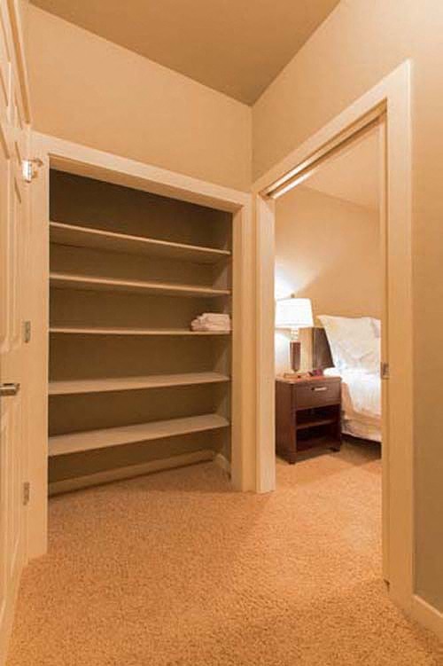 a empty closet in a bedroom with a bed