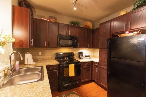 a kitchen with black appliances and brown cabinets