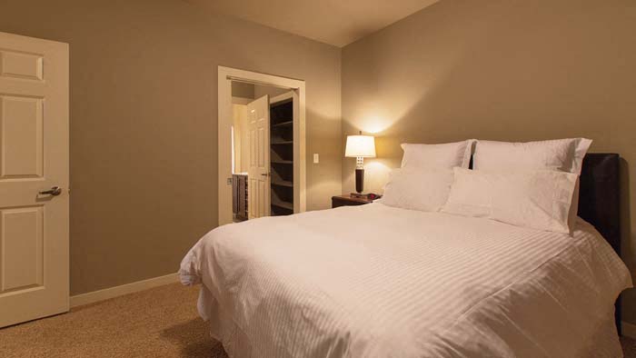 a bedroom with a large white bed and a door