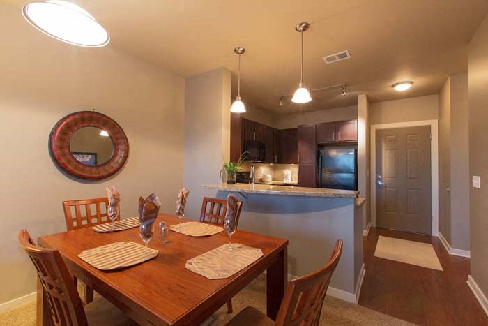 a dining room with a table and a kitchen