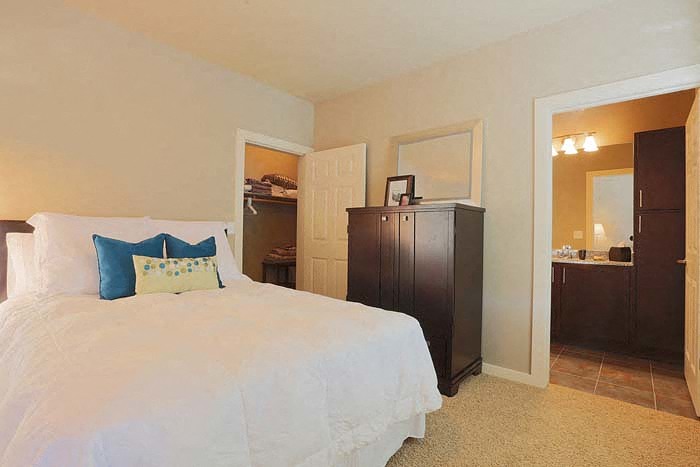 a bedroom with a bed and a dresser in it