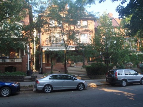 A silver car is parked on the side of the street.
