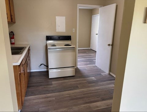 A kitchen with a white oven and a white door.