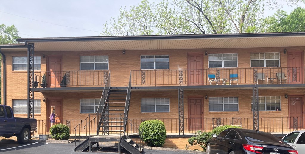 A brown building with a black truck parked in front.