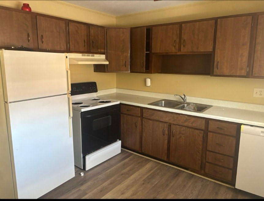 A kitchen with a white fridge and a black oven.