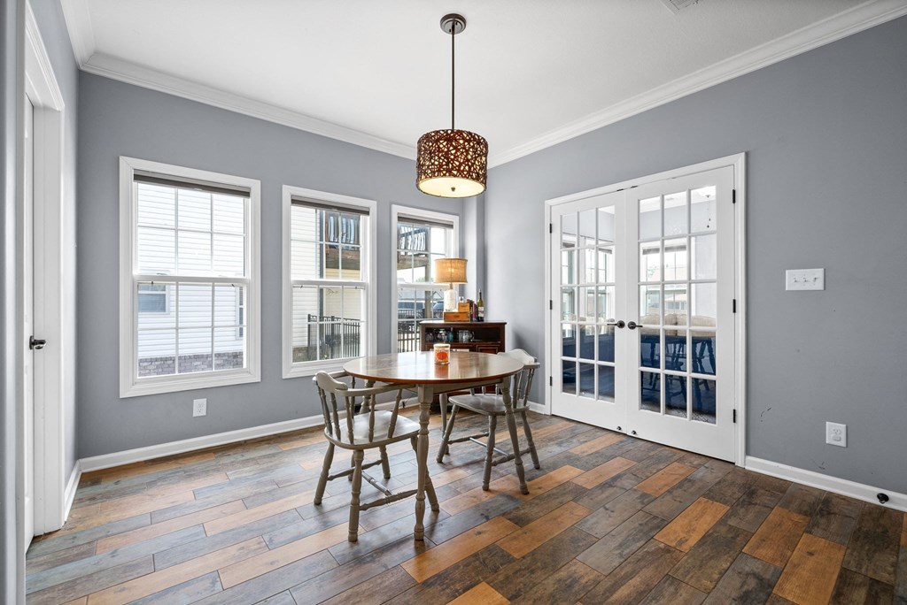 a dining room with a table and chairs and a door to a balcony