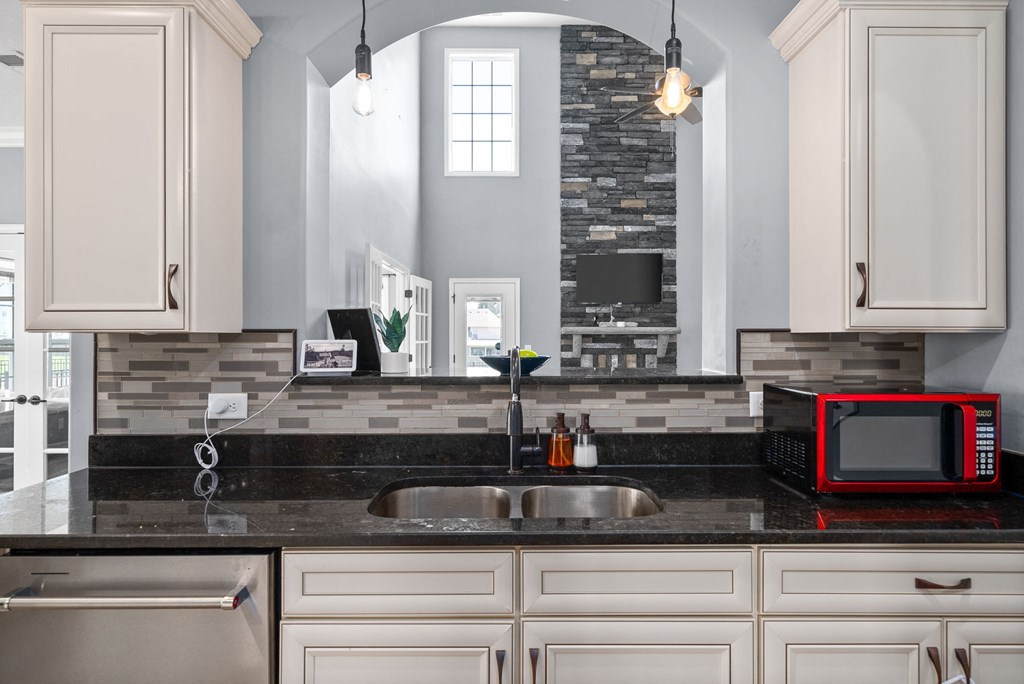 a kitchen with white cabinets and a sink and a microwave