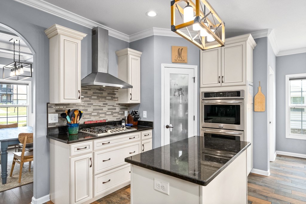 a kitchen with white cabinets and black counter tops