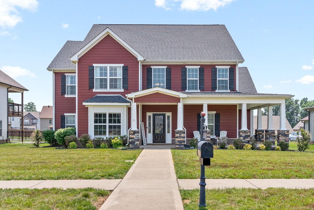 a red house with a sidewalk and a parking meter in front of it