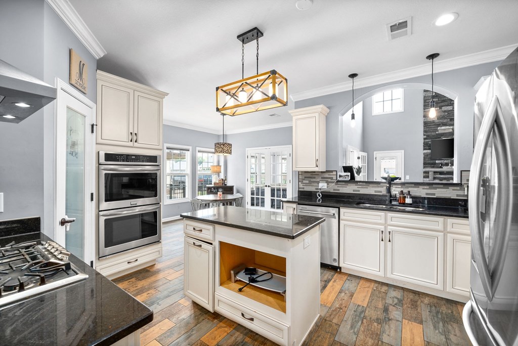 a large kitchen with white cabinets and stainless steel appliances