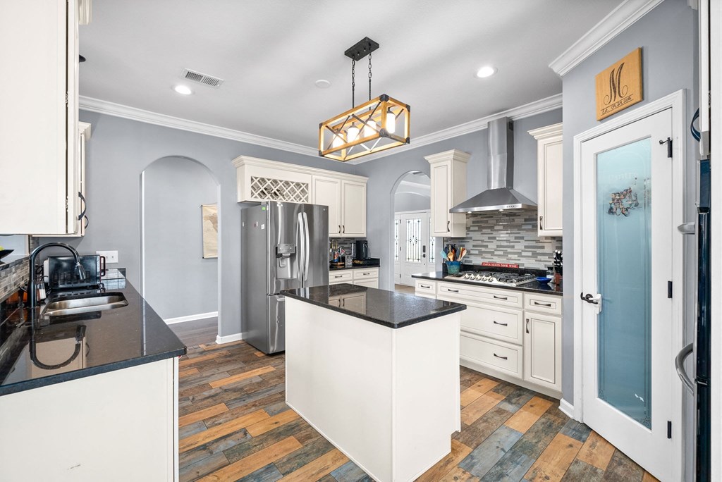 a kitchen with white cabinets and black counter tops