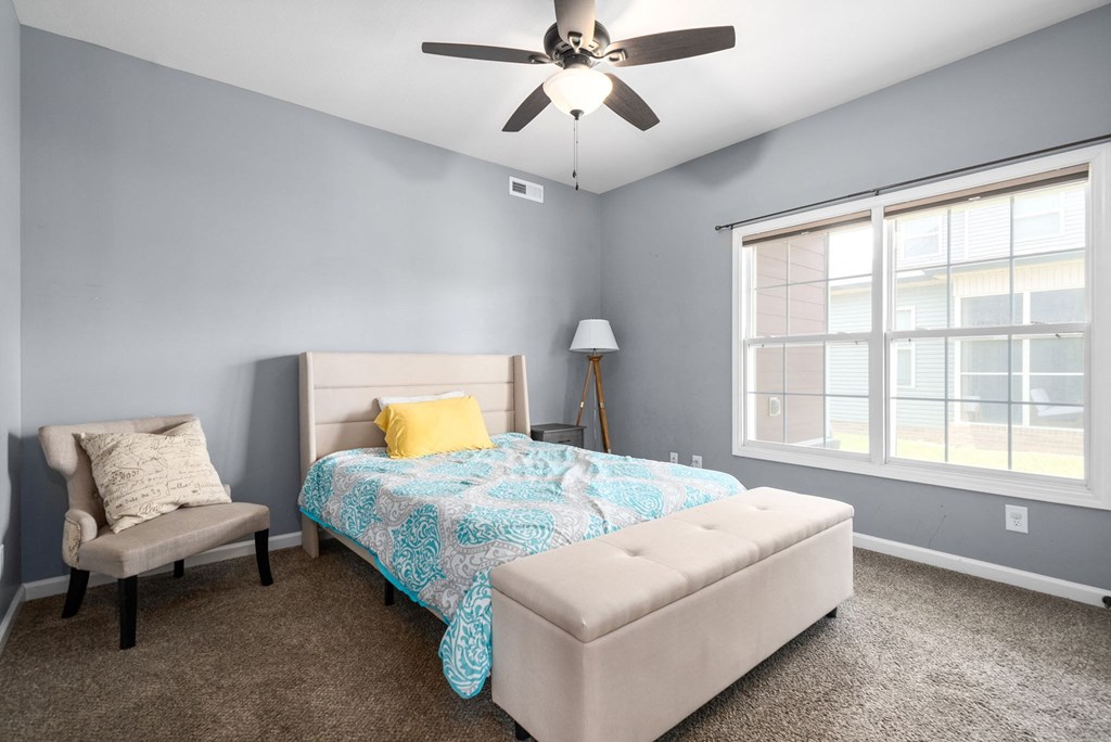 a bedroom with a bed and a ceiling fan