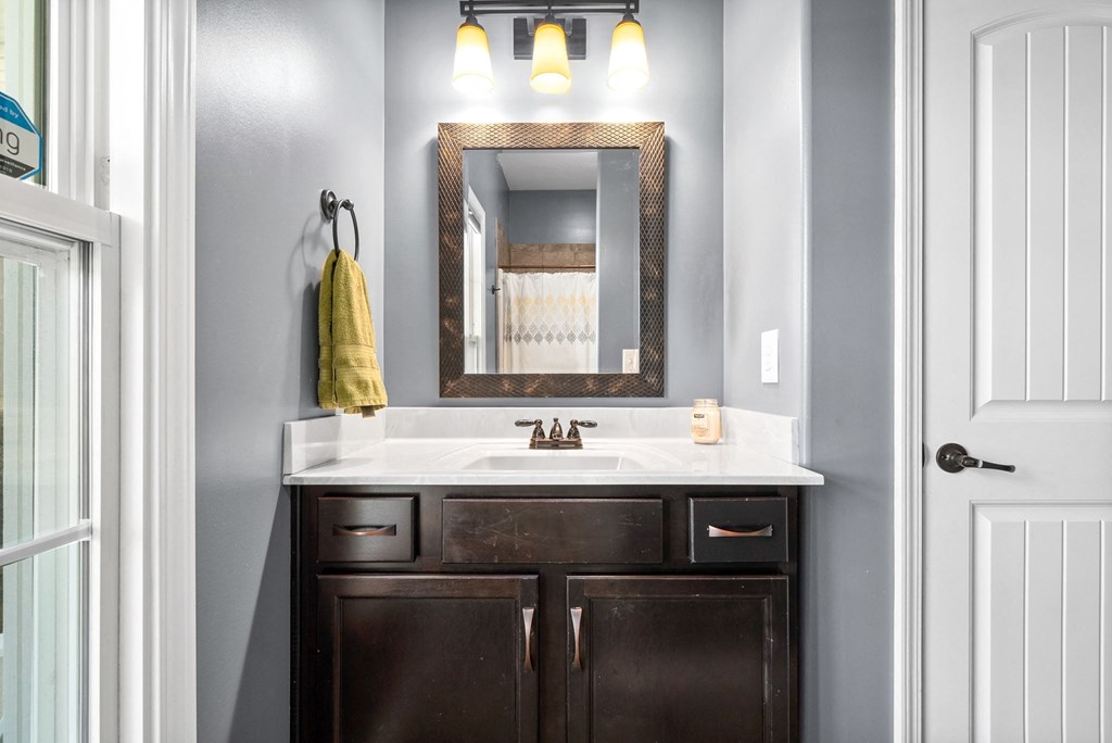 a bathroom with a sink and a mirror and a door