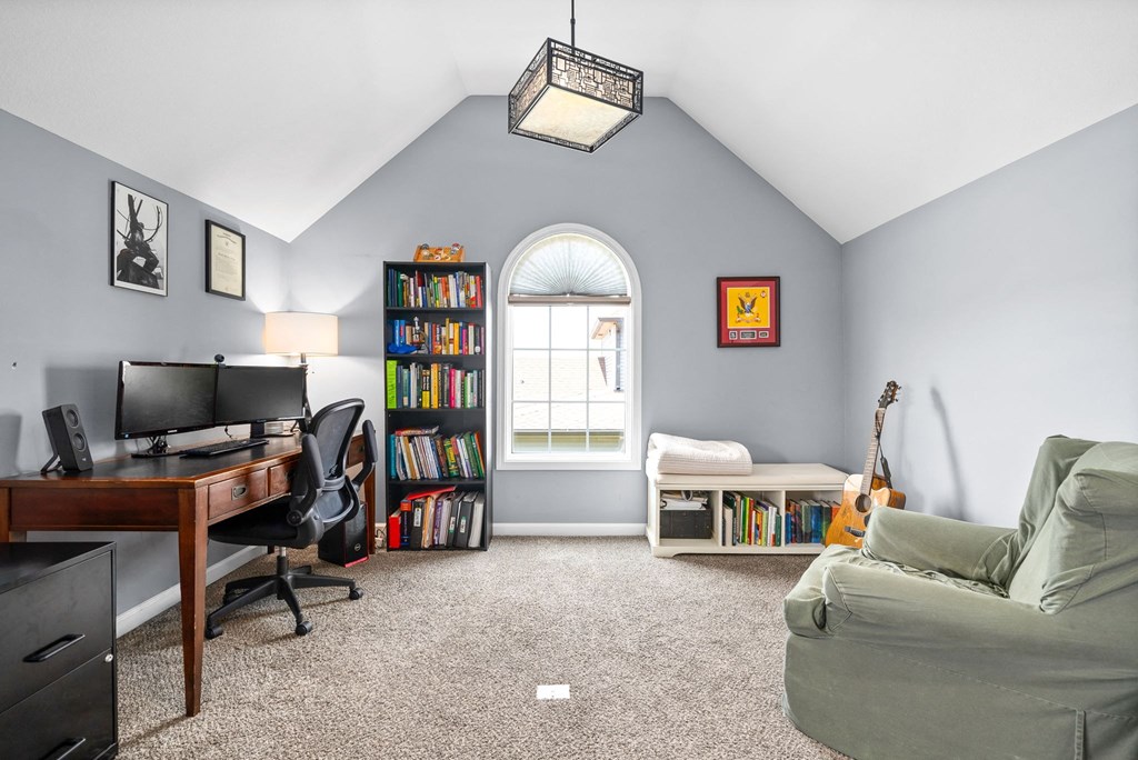 a living room with a couch and a desk and a window