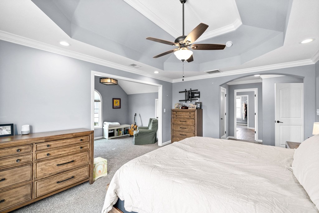 a bedroom with a large bed and a ceiling fan