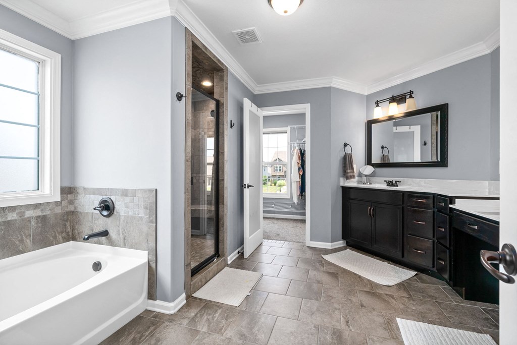 the master bathroom has a soaking tub and a walk in shower