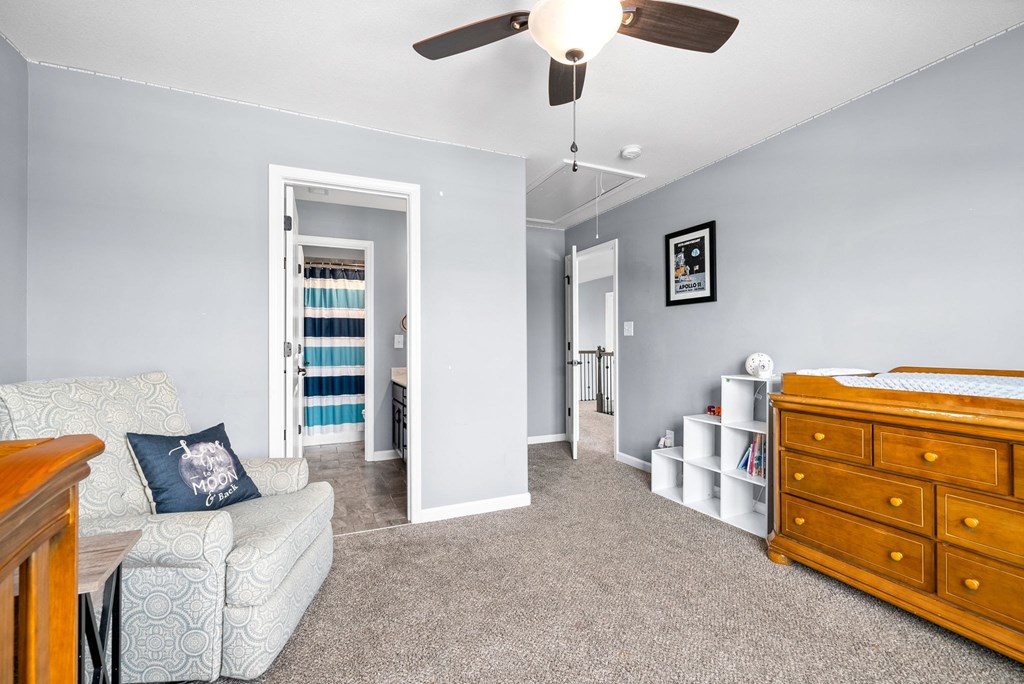 a bedroom with a bed and a dresser and a ceiling fan