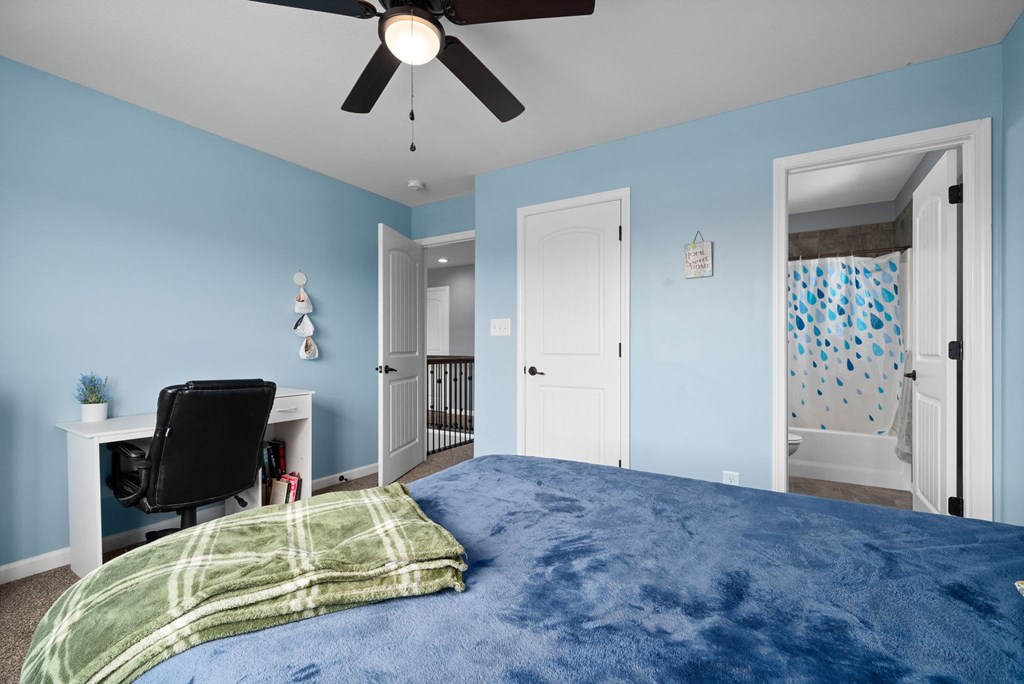 a bedroom with a large bed and a ceiling fan