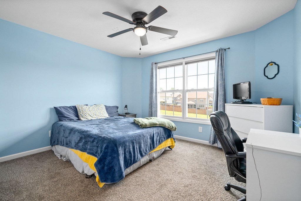 a bedroom with a bed and a ceiling fan