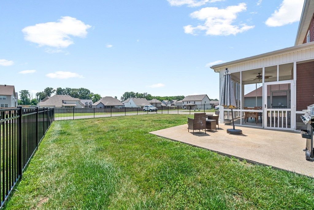 the backyard of a home with a patio and a grill
