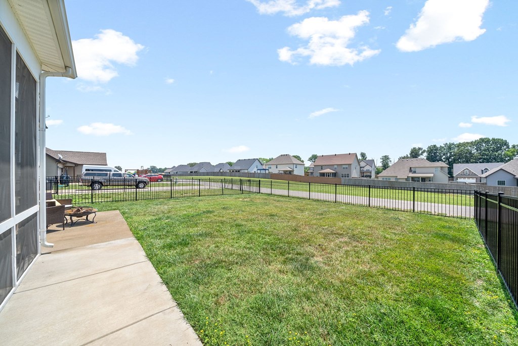 the backyard of a house with a yard and a fence