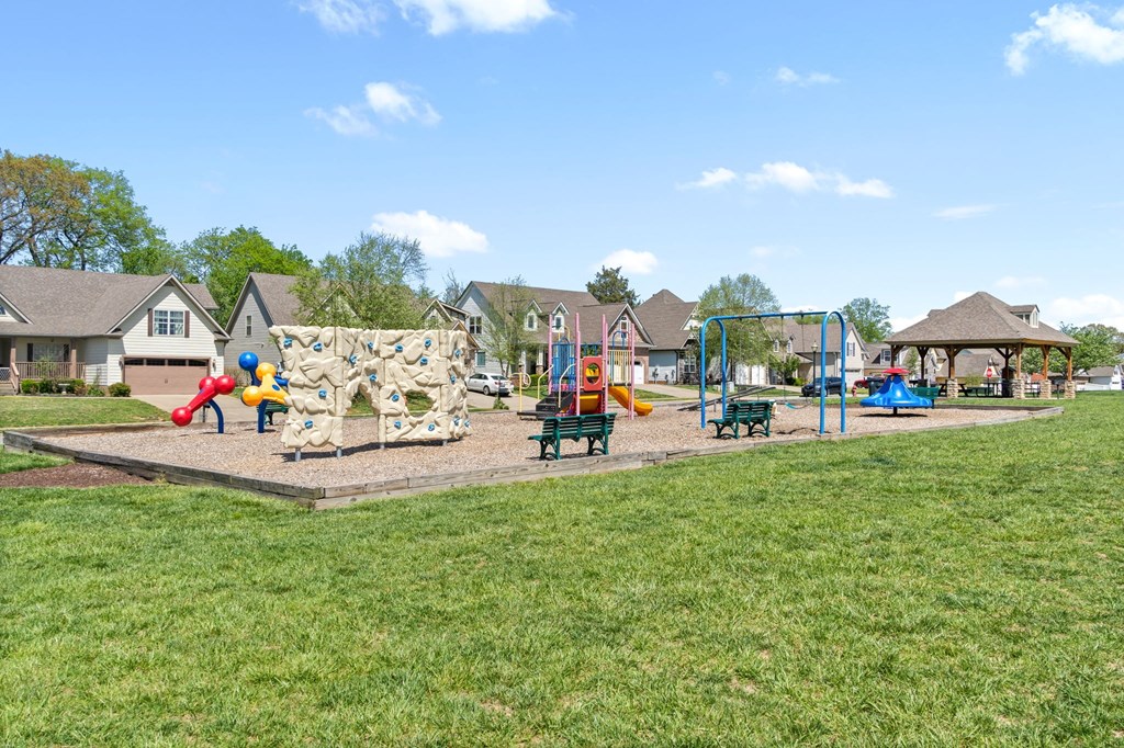a playground in a park with houses in the background