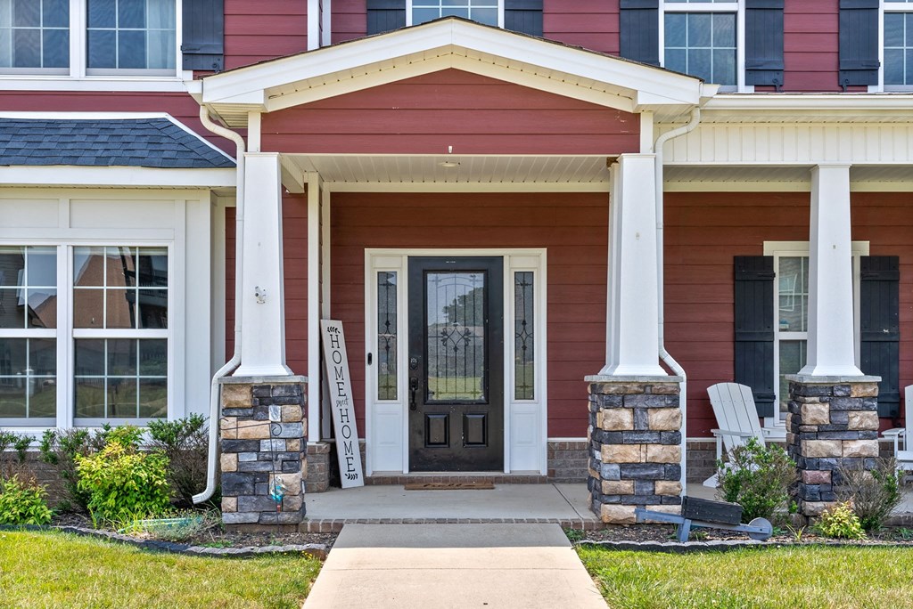a front porch of a home with a black door