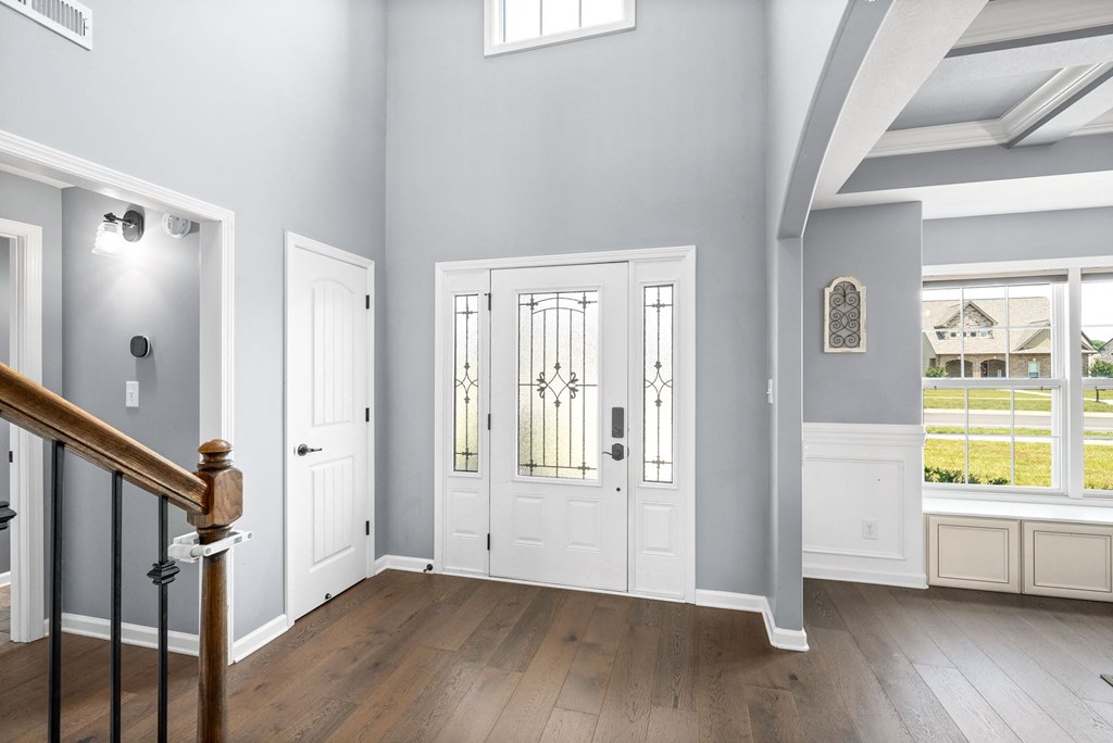 the entryway of a house with white doors and a staircase