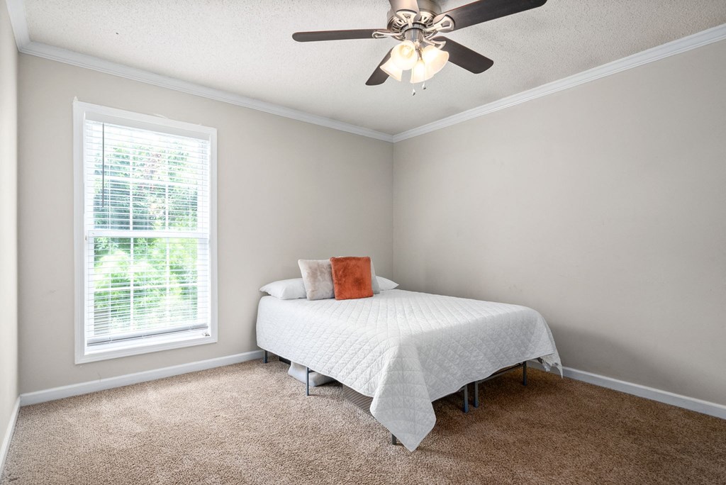 a bedroom with a bed and a ceiling fan