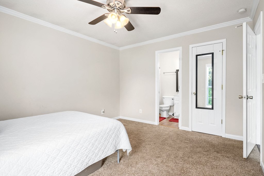 a bedroom with a bed and a ceiling fan