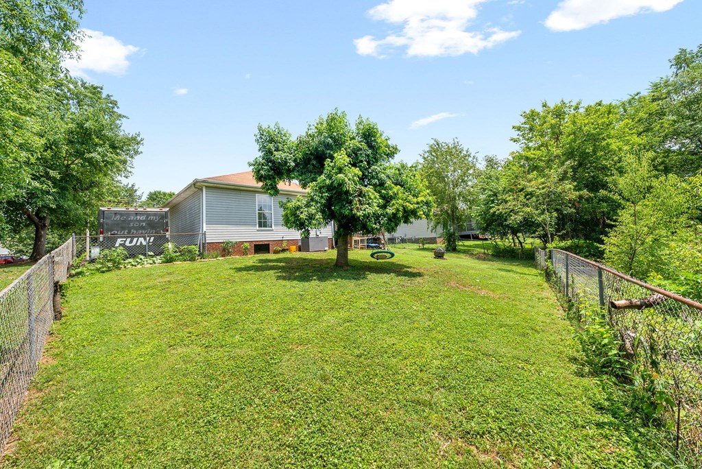 a yard with a house and a tree in the middle