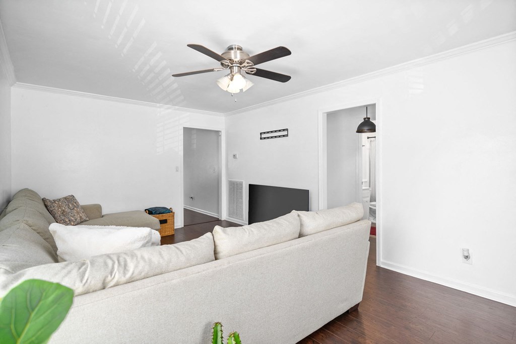 a living room with a couch and a ceiling fan