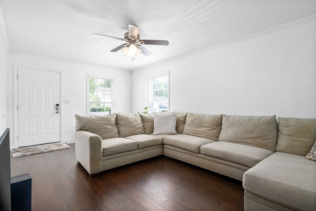 a living room with a couch and a ceiling fan