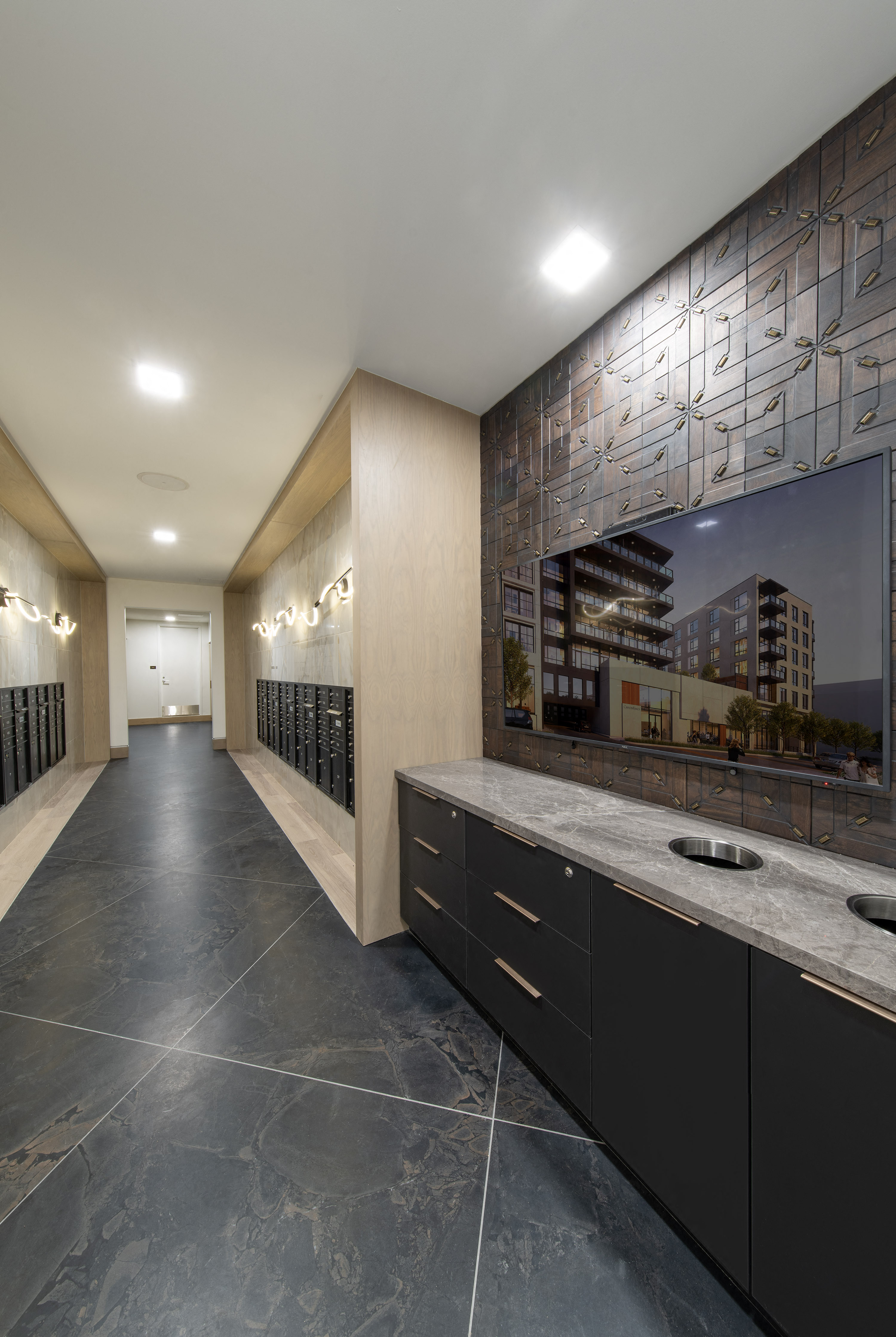 a long hallway with marble counter tops and a large mirror
