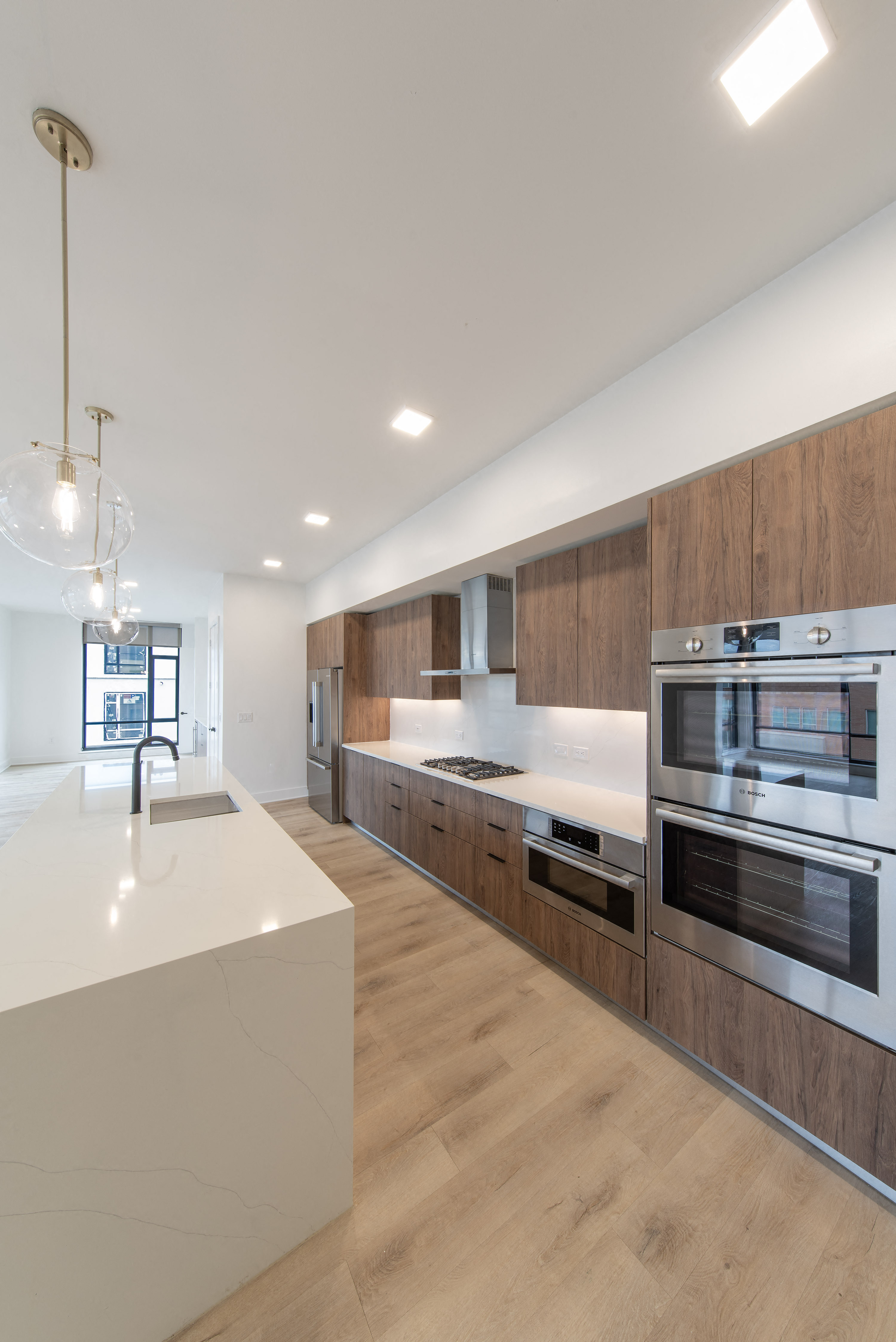 a kitchen with white countertops and wooden cabinets and stainless steel appliances
